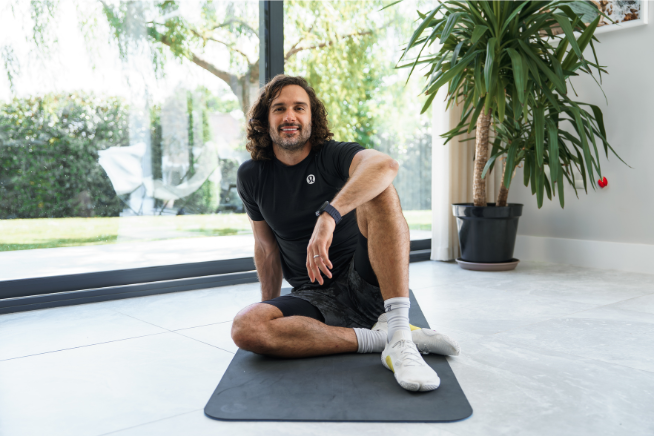 Joe Wicks smiling on a yoga mat
