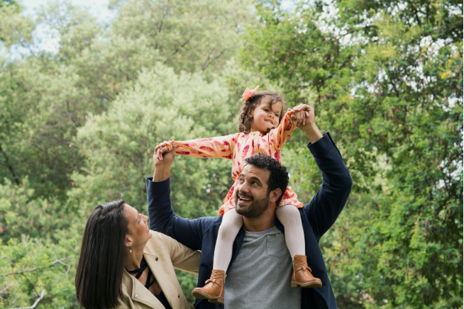 Kids on Dad's shoulders outdoors