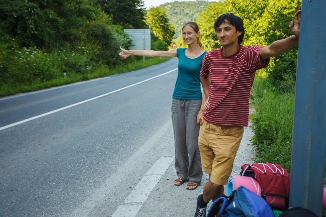 Young couple hitchhiking