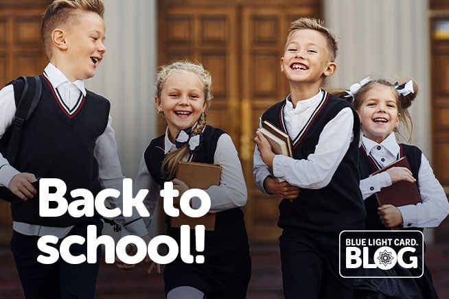 Smiling school children in uniforms holding books – Blue Light Card back-to-school savings blog.