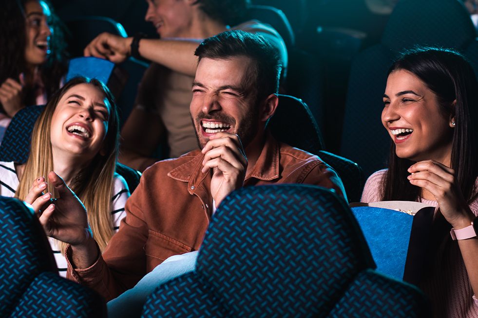 Three people laughing at the cinema 