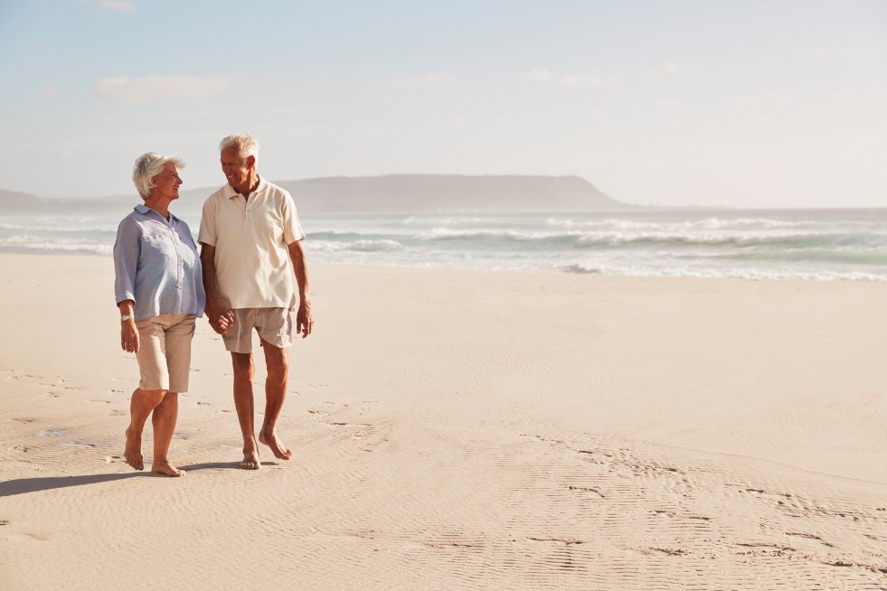 Elderly couple walking along a beach