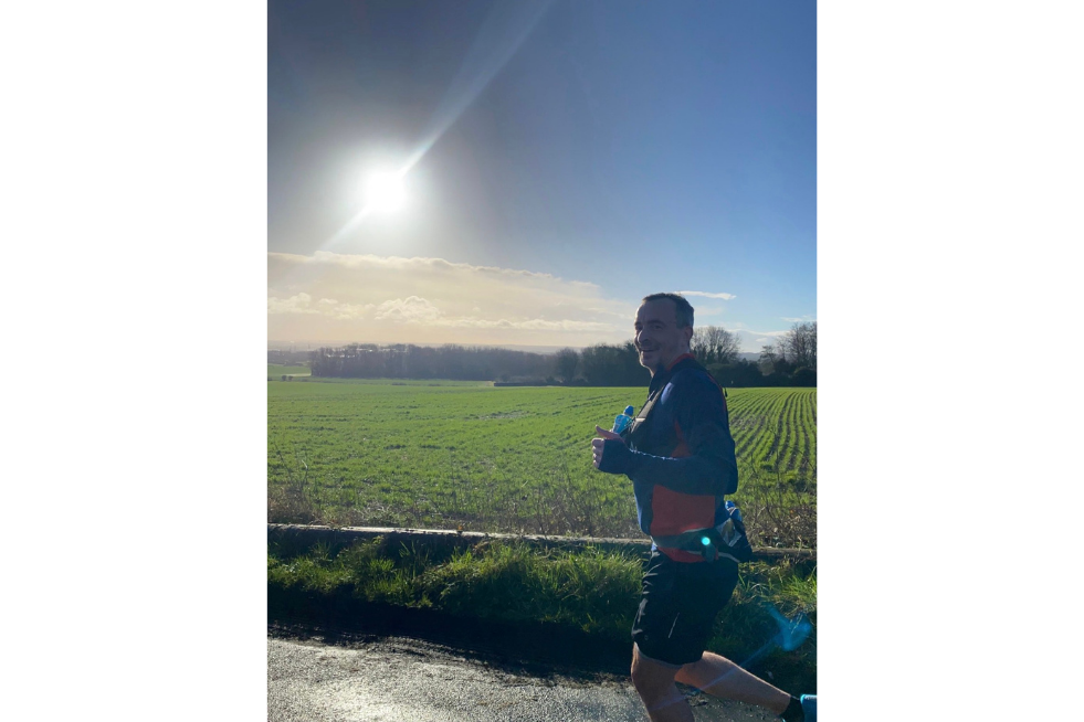 Pete the paramedic, running on a sunny day with green field in the background