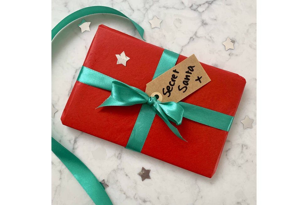 A book wrapped in red paper with a Secret Santa tag