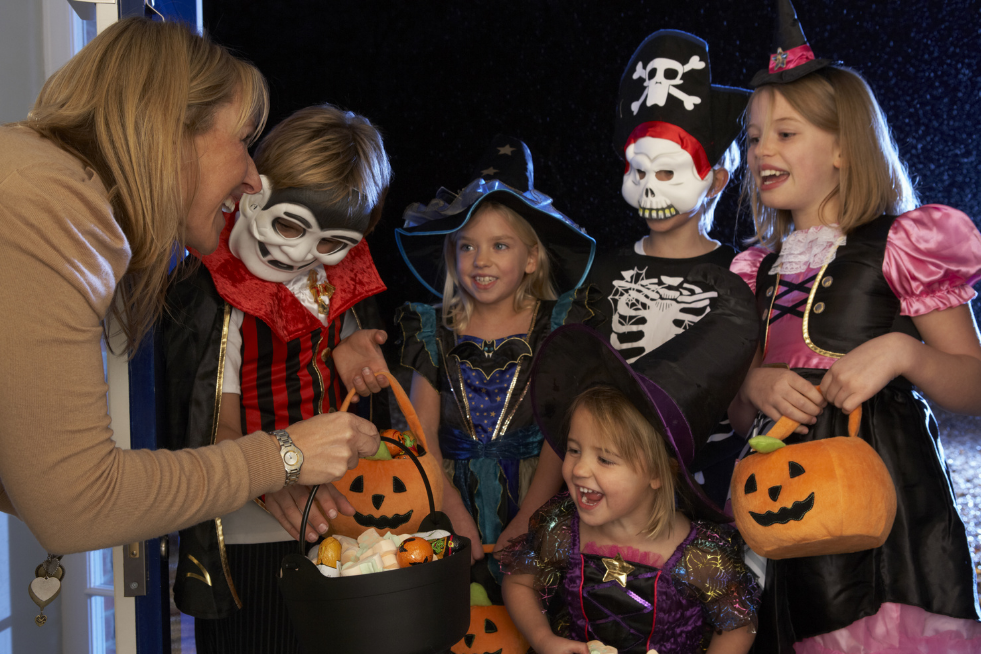A group of children dressed in Halloween costumes trick-or-treating