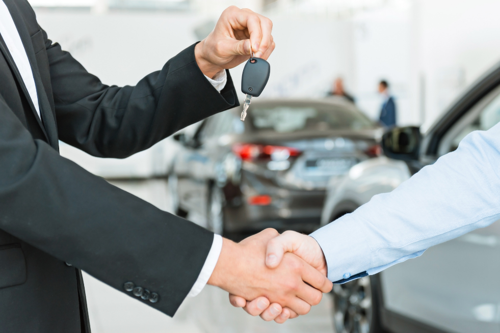 Shaking hands and a car key 