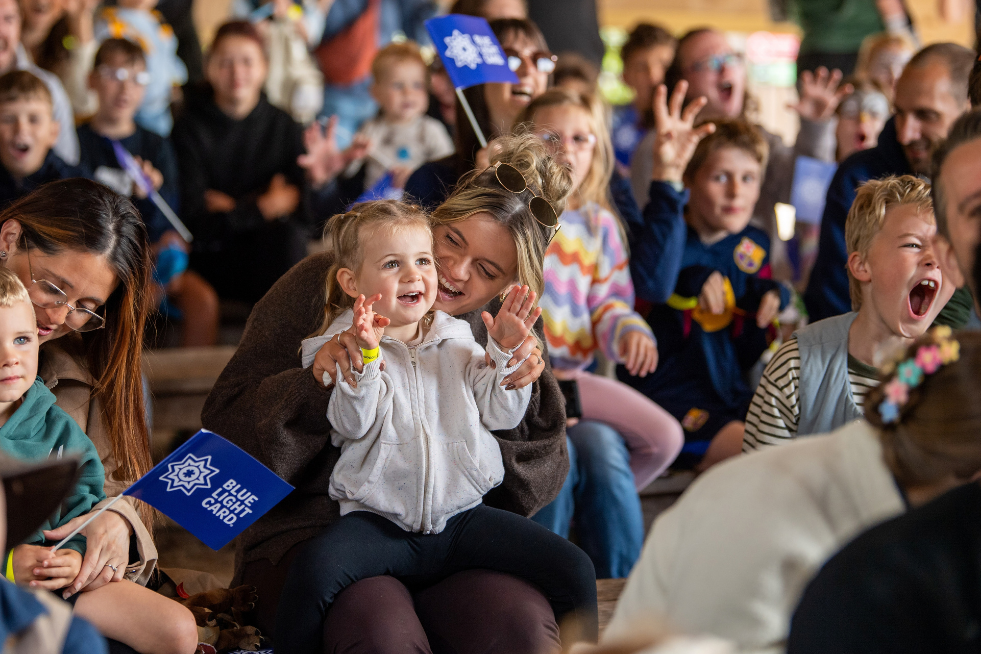 Happy children in the audience watching a show at the Blue Light Card member day