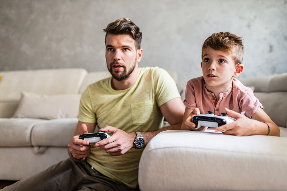 Dad and son playing video games together