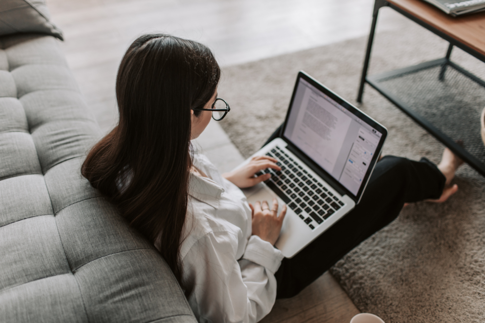Woman sat on the floor with a laptop