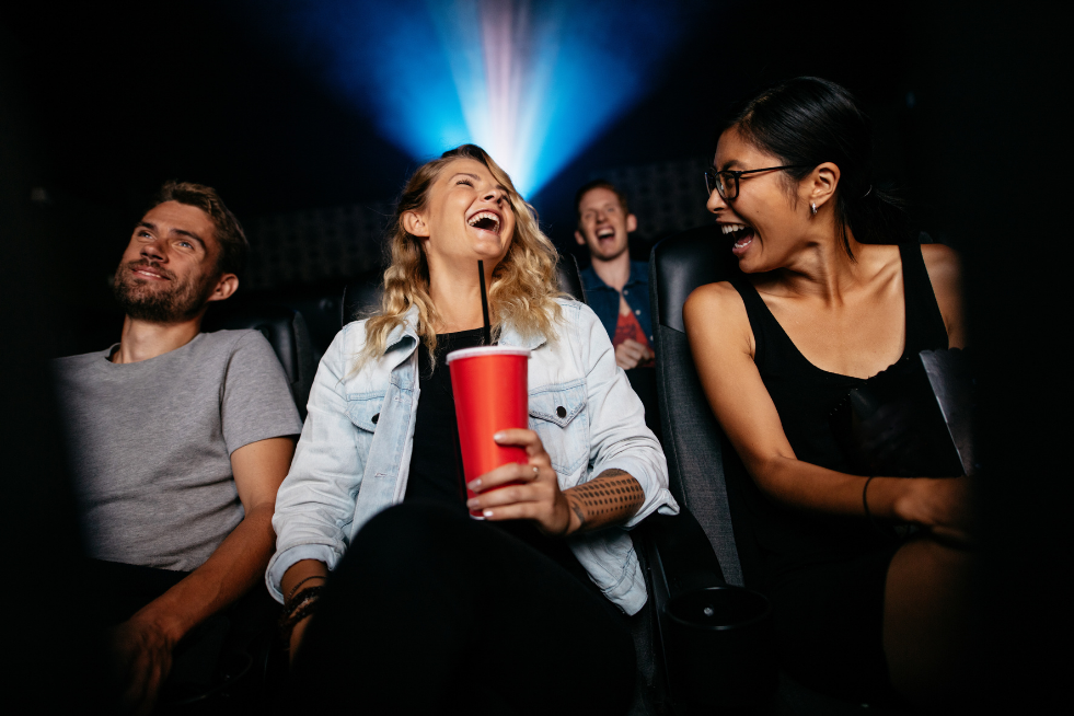 Three people at the cinema laughing 