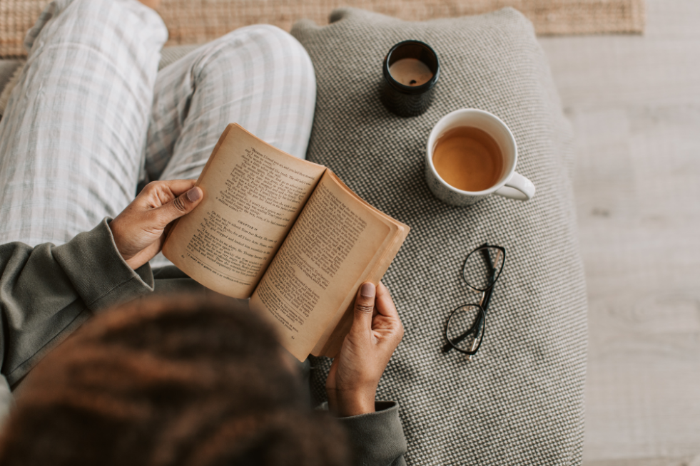 Reading a book with a cup of tea and glasses