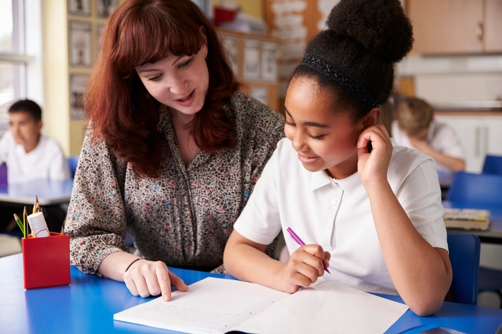 A teacher reading with a student