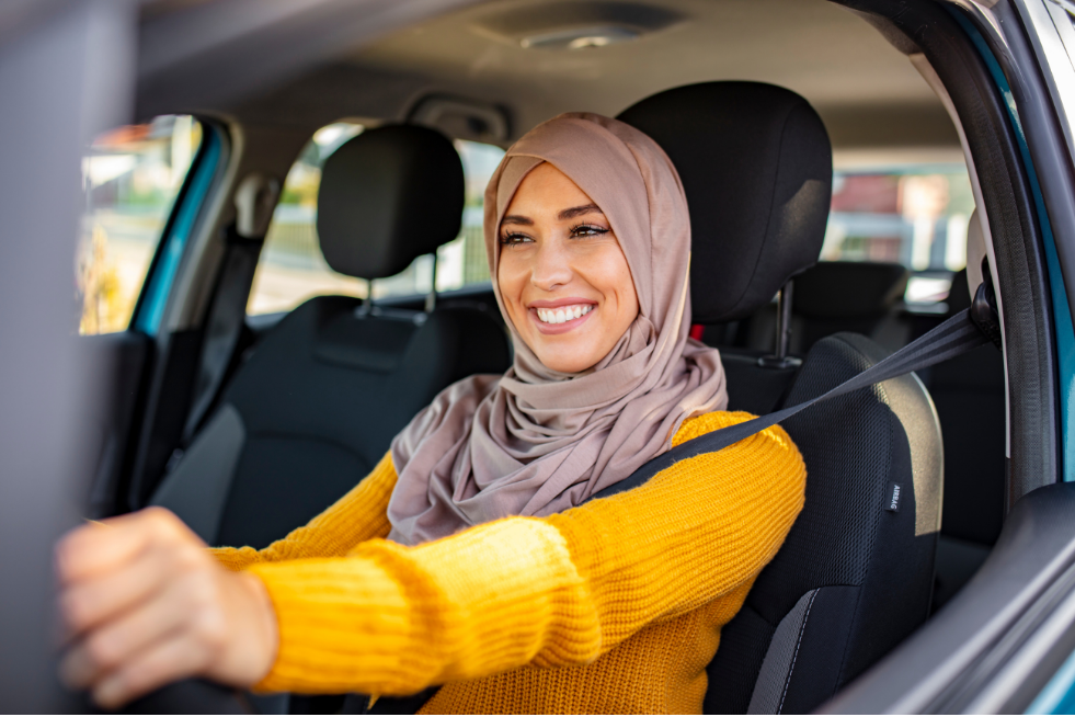 A woman driving a car smiling 