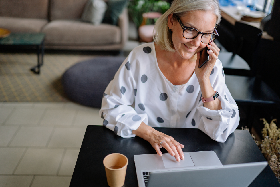 A woman on the phone whilst working on her laptop