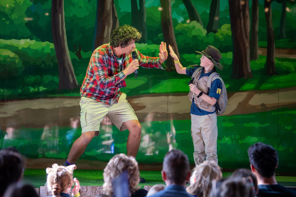 Andy Day on stage high-fiving a child
