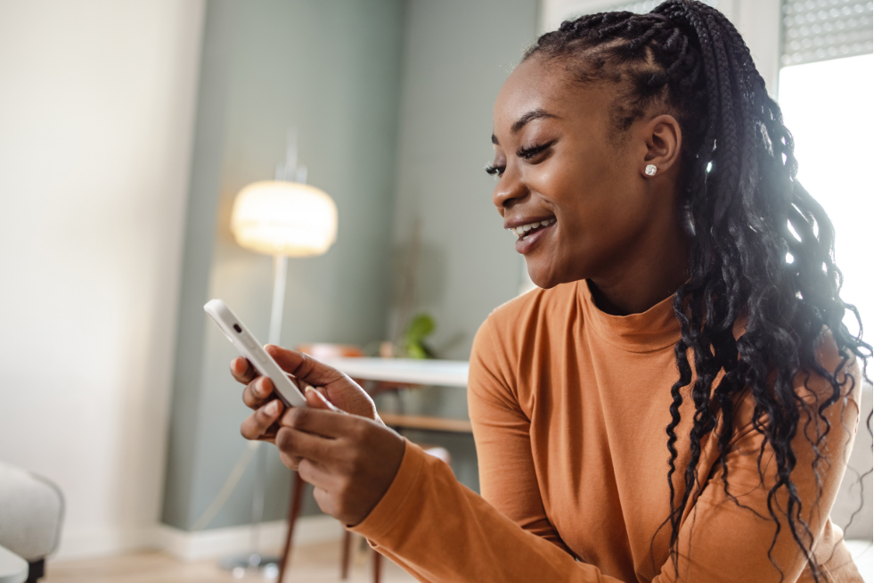 A woman looking at her phone while at home 