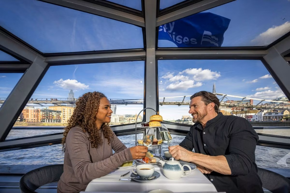 Two people drinking and eating afternoon tea on the Thames