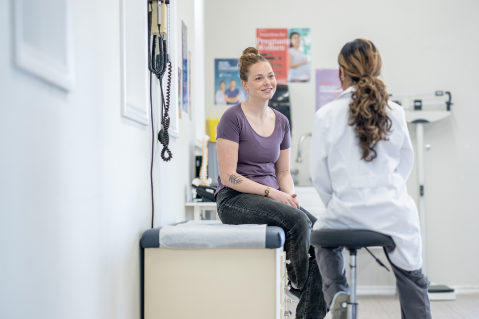 A woman speaking with a doctor in a doctor's office