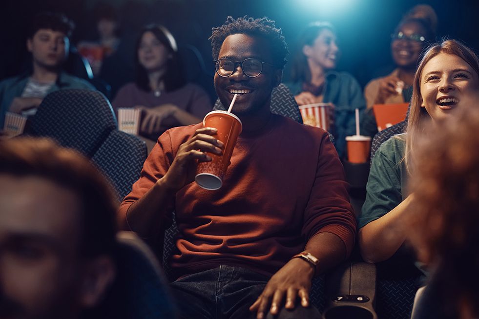 A man having a drink at the cinema 
