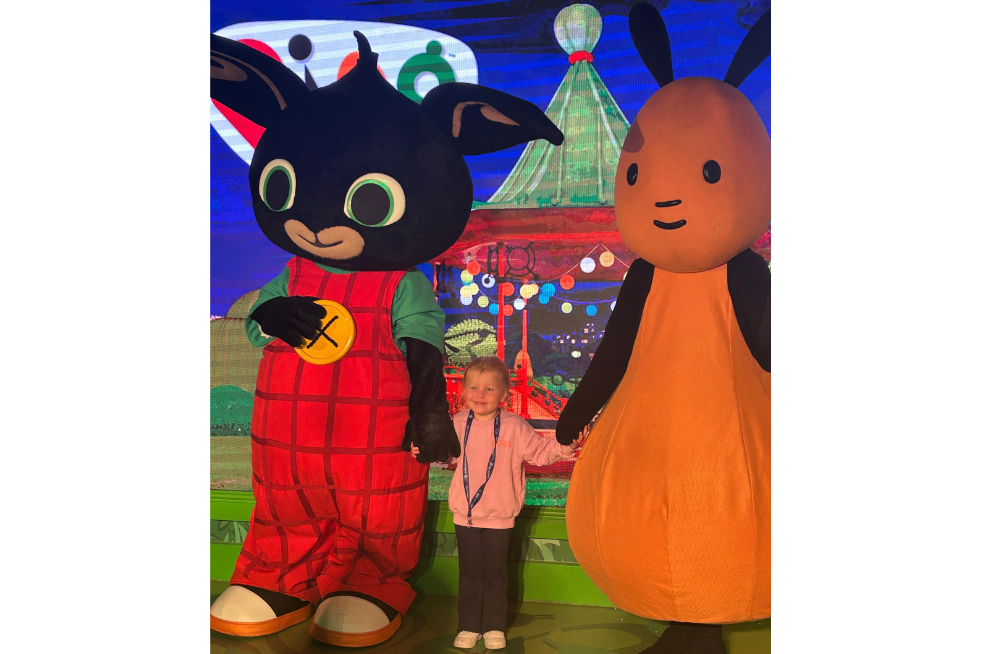 Young girl holding hands with Bing and Flop