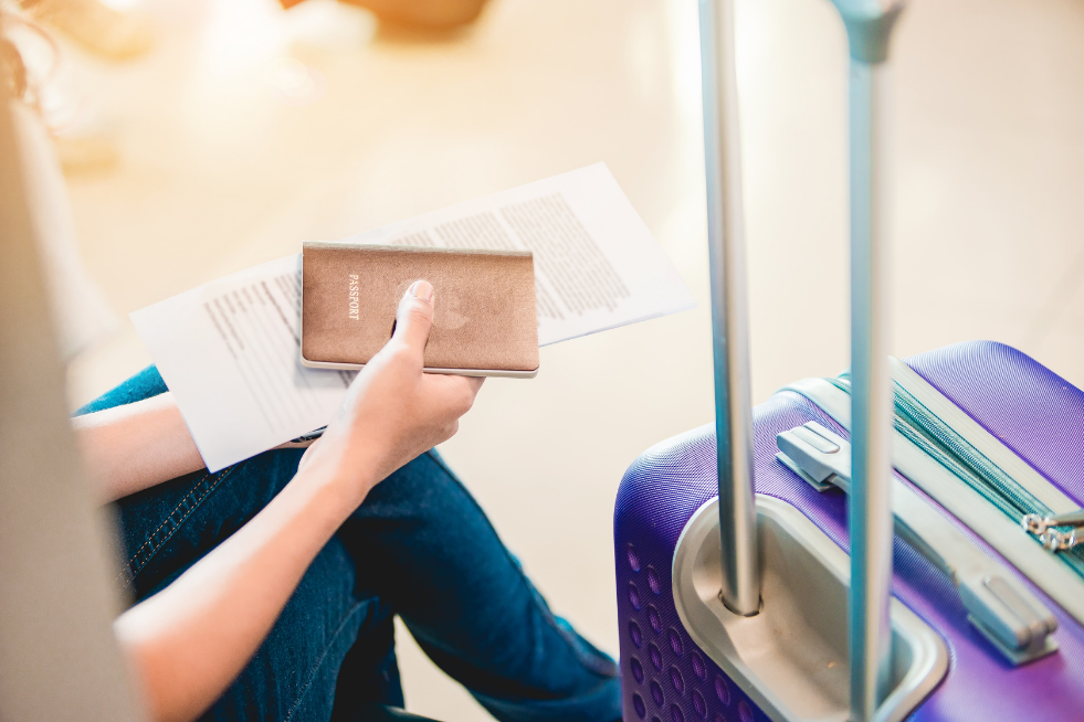 A person with a passport and suitcase