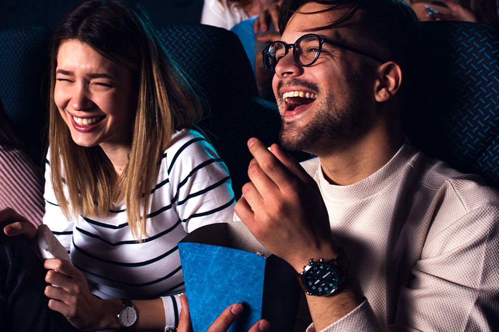 Two people at the cinema, one eating popcorn 