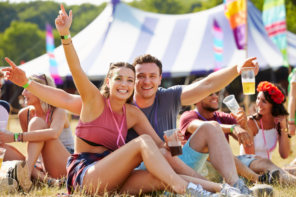 Two people posing outdoors at a music festival