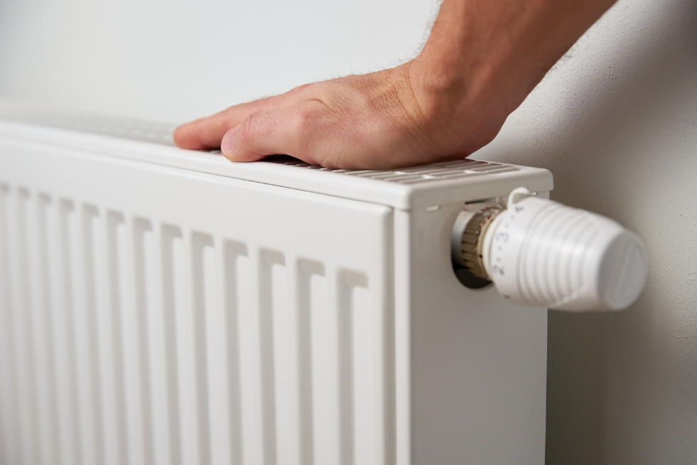 A hand touching the top of a radiator