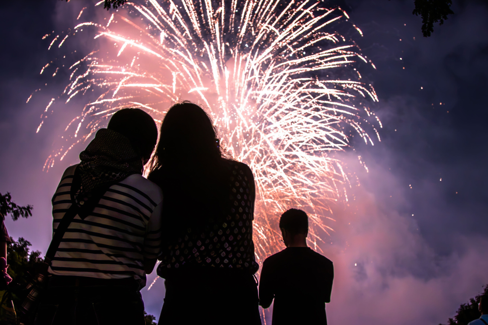 Two people staring up at a firework display