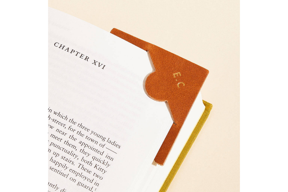 An orange corner bookmark with initials