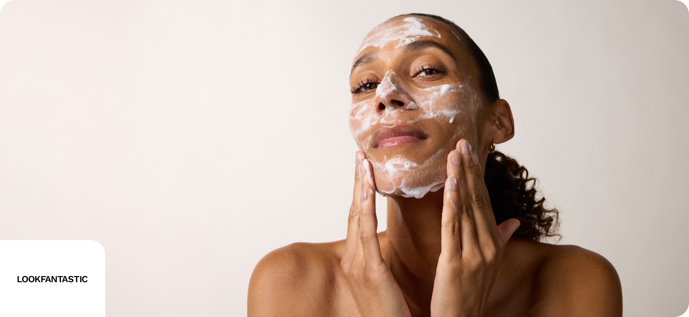 LOOKFANTASTIC discounts banner image showing a woman applying cosmetics